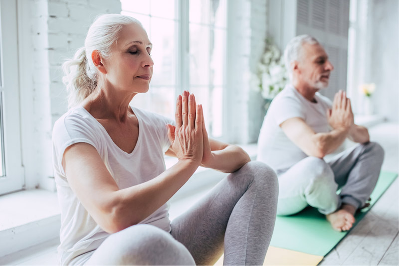 Starsza para podczas medytacji niwelującej stres